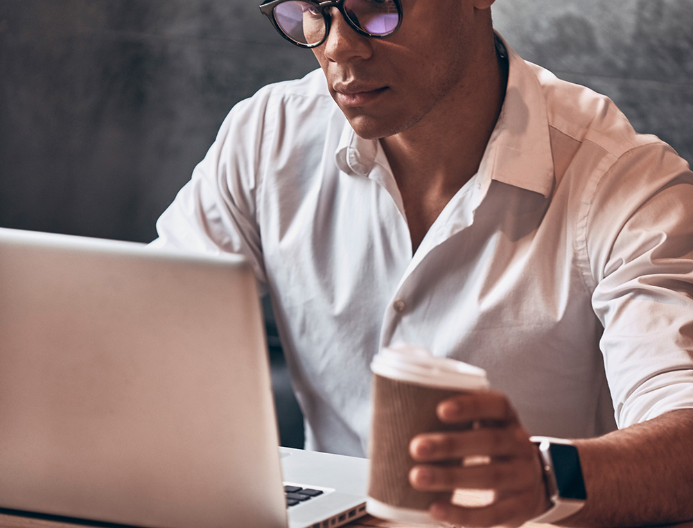 Confident Young African Man In Smart Casual Wear Using Laptop Wh - Barão Assessoria Contábil