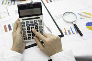 Asian Accountant Working And Analyzing Financial Reports Project - Barão Assessoria Contábil